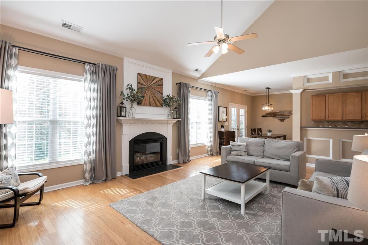 7724 Braefield Drive Raleigh, NC 27616 - Photo 16 of 27 a living room with furniture a fireplace and a large window