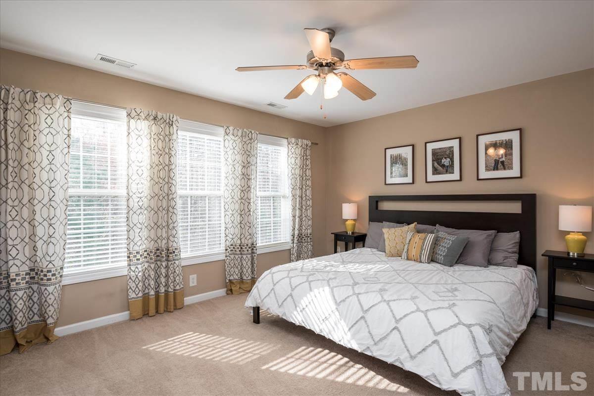 7724 Braefield Drive Raleigh, NC 27616 - Photo 17 of 27 a bedroom with a large bed and a chandelier fan