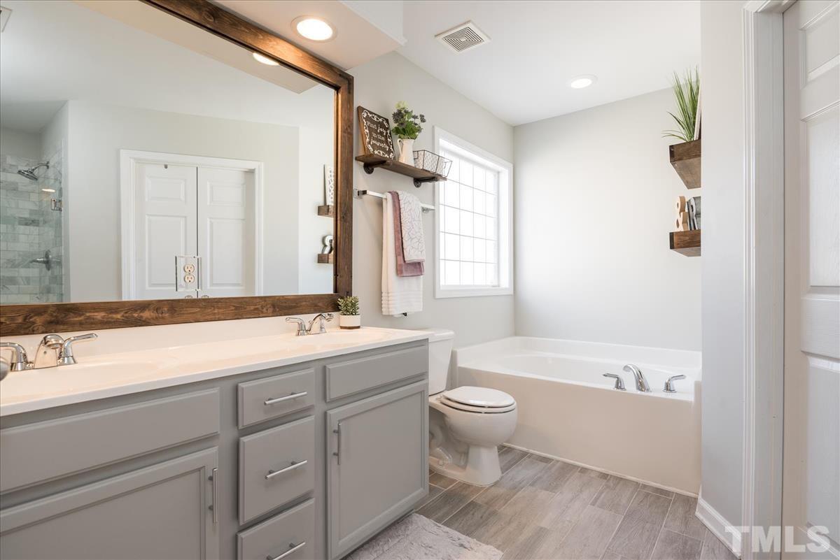 7724 Braefield Drive Raleigh, NC 27616 - Photo 18 of 27 a bathroom with a double vanity sink mirror and bathtub