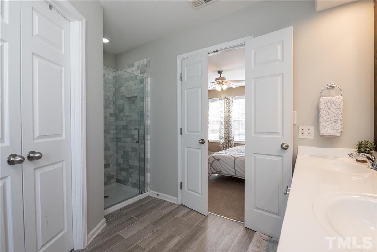 7724 Braefield Drive Raleigh, NC 27616 - Photo 19 of 27 a bathroom with a tub shower and bedroom