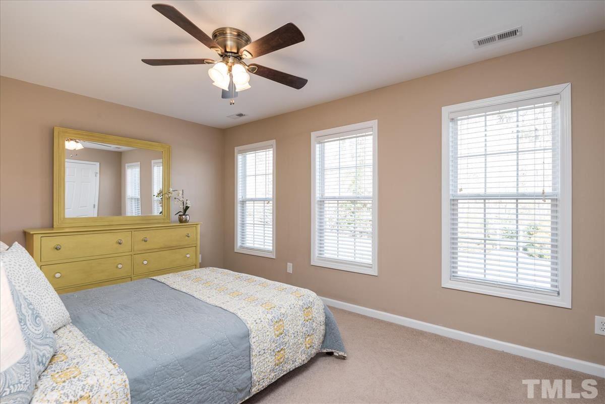 7724 Braefield Drive Raleigh, NC 27616 - Photo 20 of 27 a bedroom with a bed and a chandelier