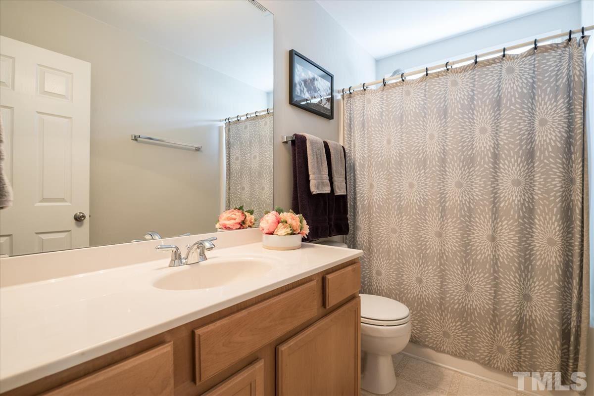7724 Braefield Drive Raleigh, NC 27616 - Photo 21 of 27 a bathroom with a sink a toilet and shower curtain