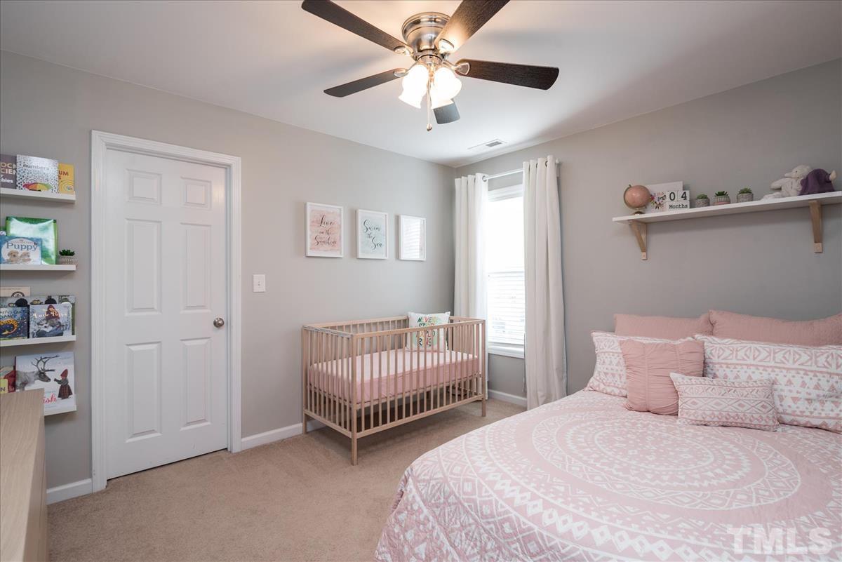 7724 Braefield Drive Raleigh, NC 27616 - Photo 22 of 27 a bedroom with two beds and a chandelier