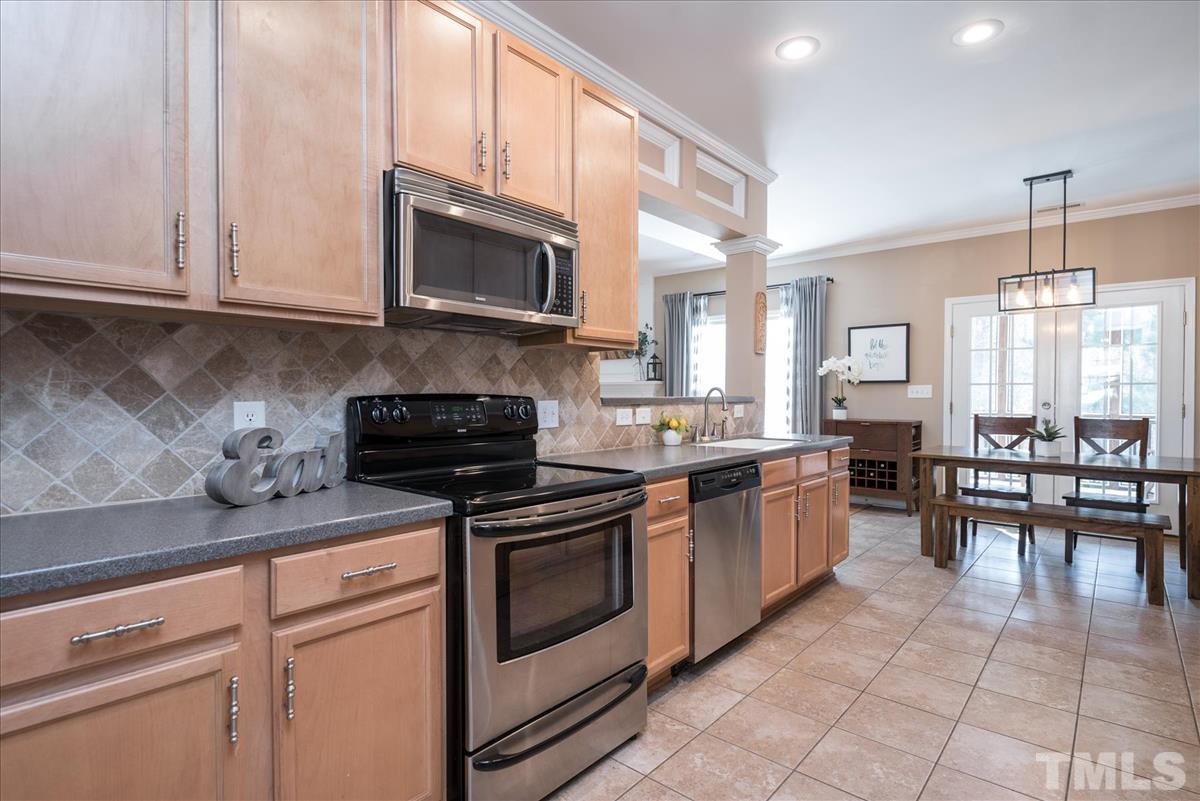 7724 Braefield Drive Raleigh, NC 27616 - Photo 8 of 27 a kitchen with stainless steel appliances granite countertop a stove a sink and a microwave
