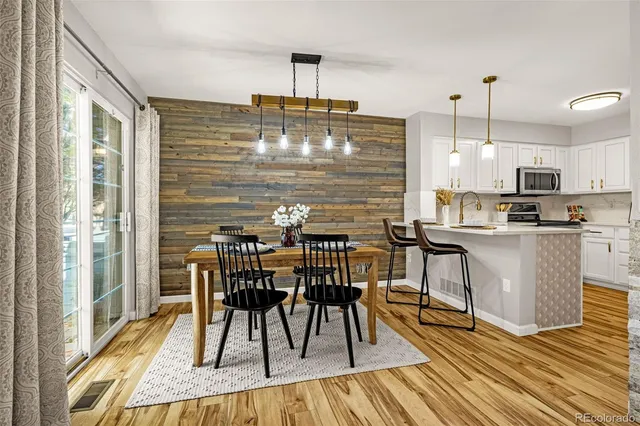 a kitchen with granite countertop kitchen island stainless steel appliances a dining table chairs and granite top