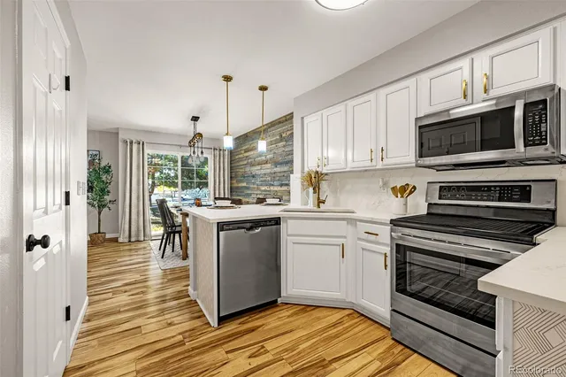 a kitchen with stainless steel appliances granite countertop a stove a sink and a microwave