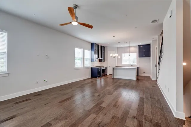 a view of a kitchen with wooden floor a sink and windows