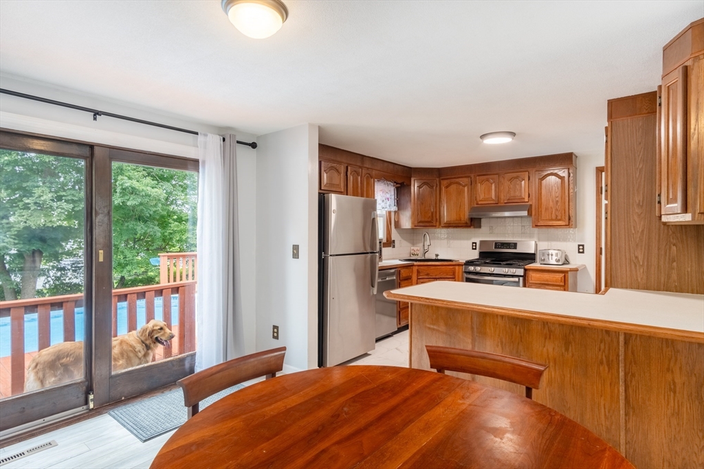 68 Sawmill Road Springfield, MA 01118 - Photo 6 of 25 a kitchen with stainless steel appliances granite countertop a refrigerator a sink dishwasher a stove and a dining table with wooden floor