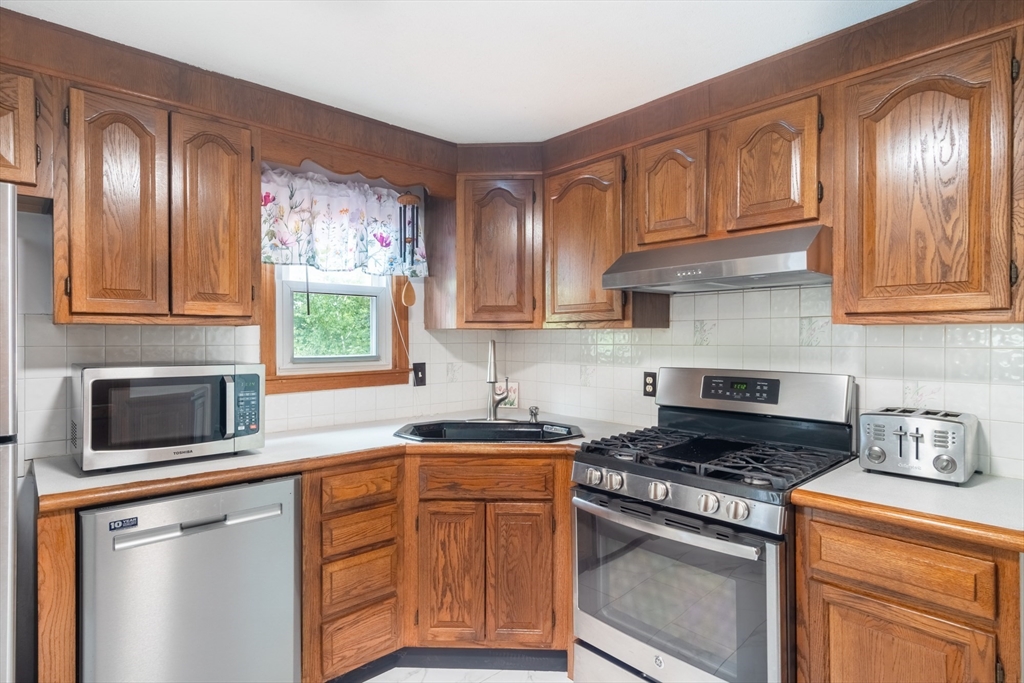 68 Sawmill Road Springfield, MA 01118 - Photo 8 of 25 a kitchen with stainless steel appliances granite countertop a stove sink microwave and cabinets