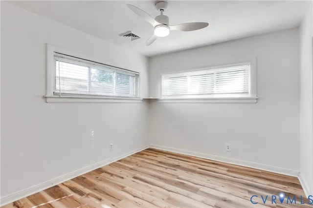 a view of a hallway with wooden floor and entryway