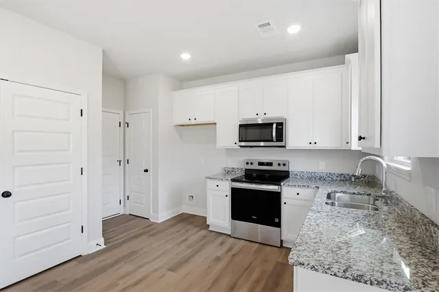 a kitchen with stainless steel appliances granite countertop a stove top oven a sink and a granite counter tops