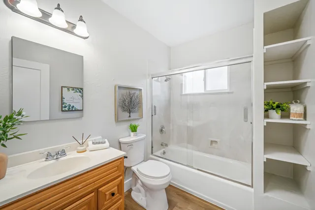 a bathroom with a sink a toilet and shower