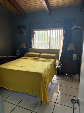 a bed sitting in a bedroom next to a window