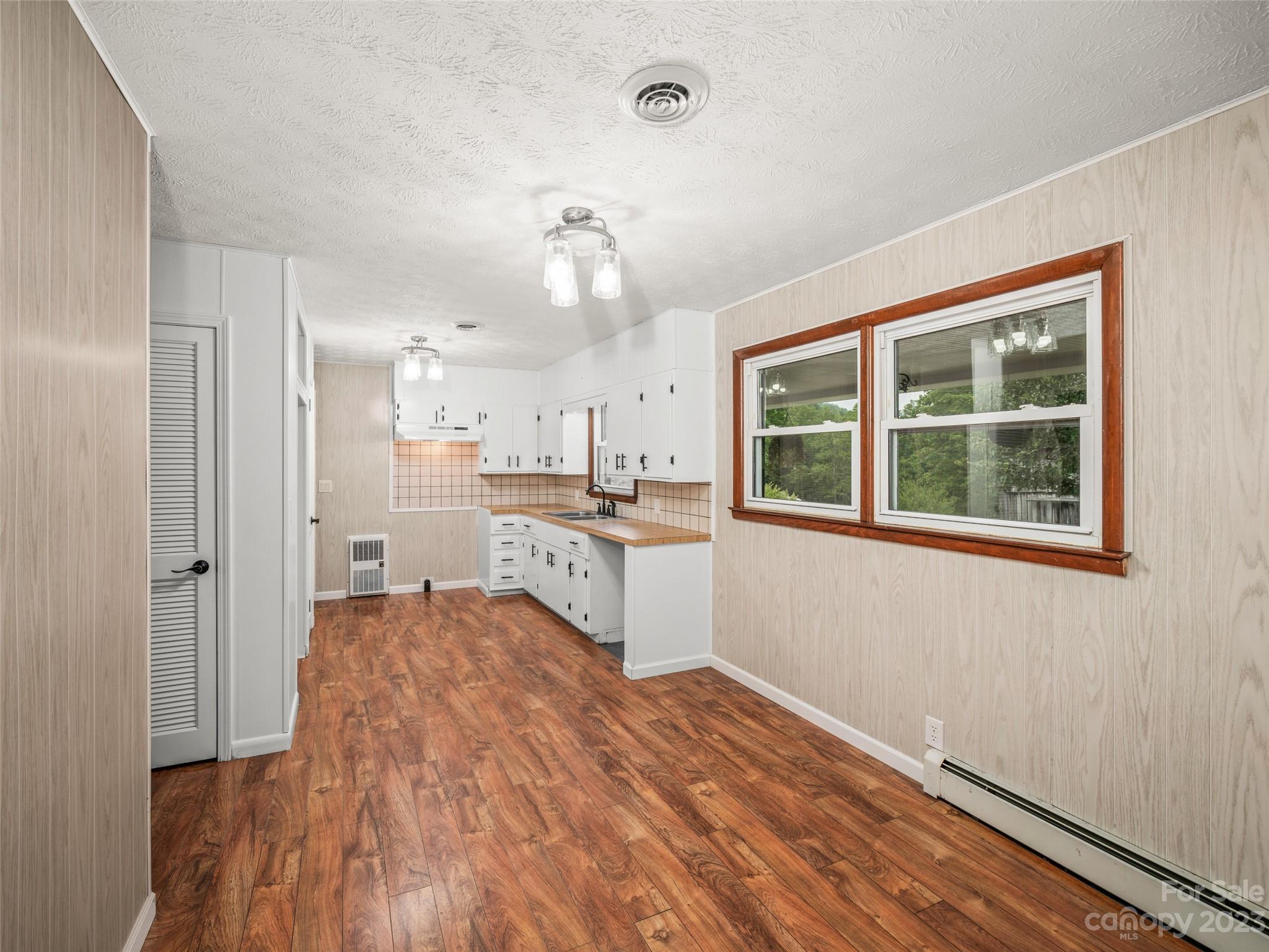 70 Letterman Road Green Mountain, NC 28740 - Photo 11 of 23 a open kitchen with white cabinets and wooden floor