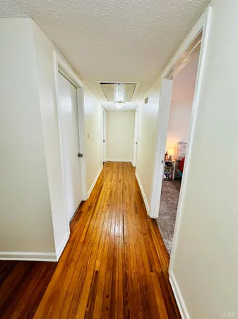 a view of a hallway with wooden floor and staircase