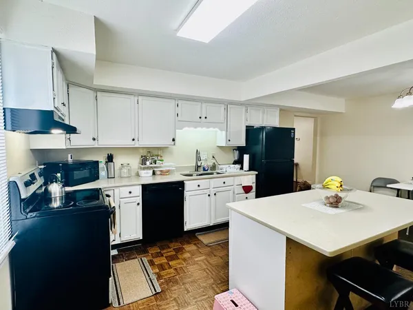 a kitchen with a sink a stove a refrigerator and white cabinets