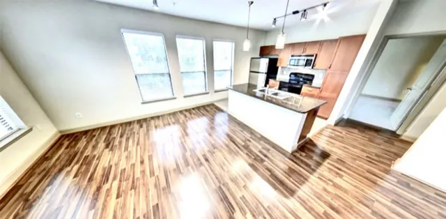 a living room with a floor to ceiling window and wooden floor