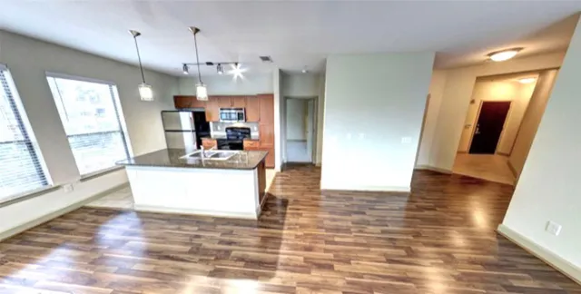 a view of a living room and kitchen with wooden floor