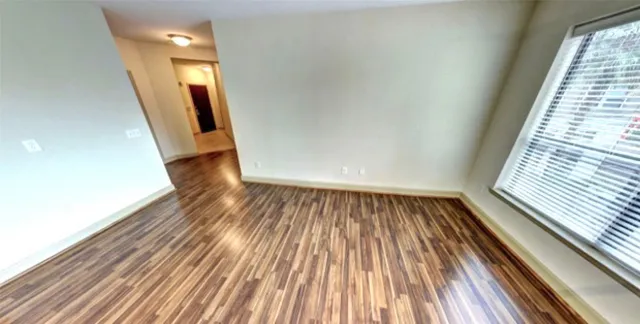 a view of a hallway with wooden floor and entryway