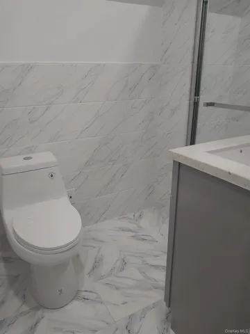 a white toilet sitting next to a shower