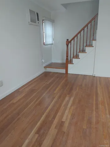a view of staircase with white walls and a wooden floor