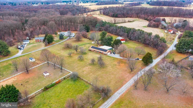 a view of a dining room with furniture a chandelier and large windows
