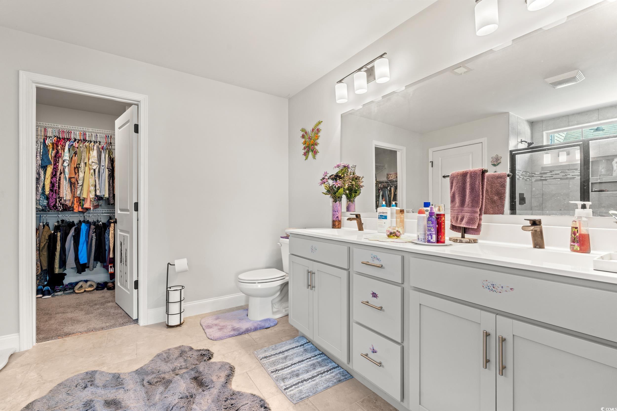 132 Fox Den Drive Murrells Inlet, SC 29576 - Photo 11 of 35 Bathroom featuring a walk in closet, double vanity, a shower stall, and light tile patterned floors