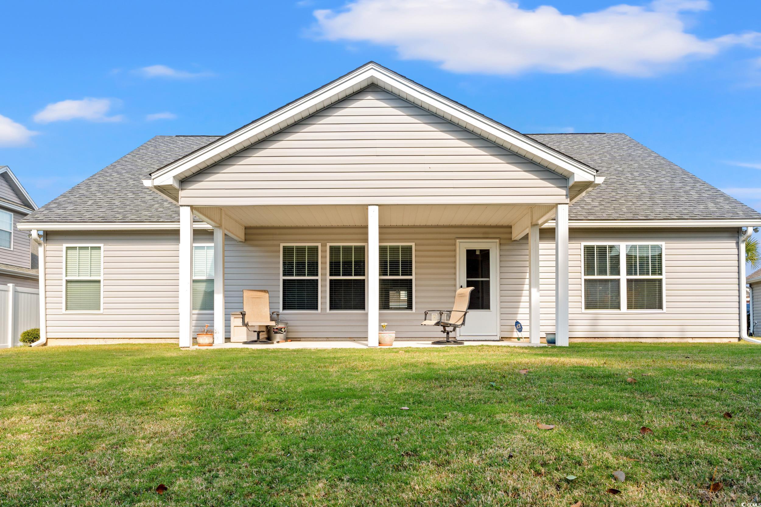 132 Fox Den Drive Murrells Inlet, SC 29576 - Photo 24 of 35 Back of property featuring a shingled roof, a lawn, and a patio