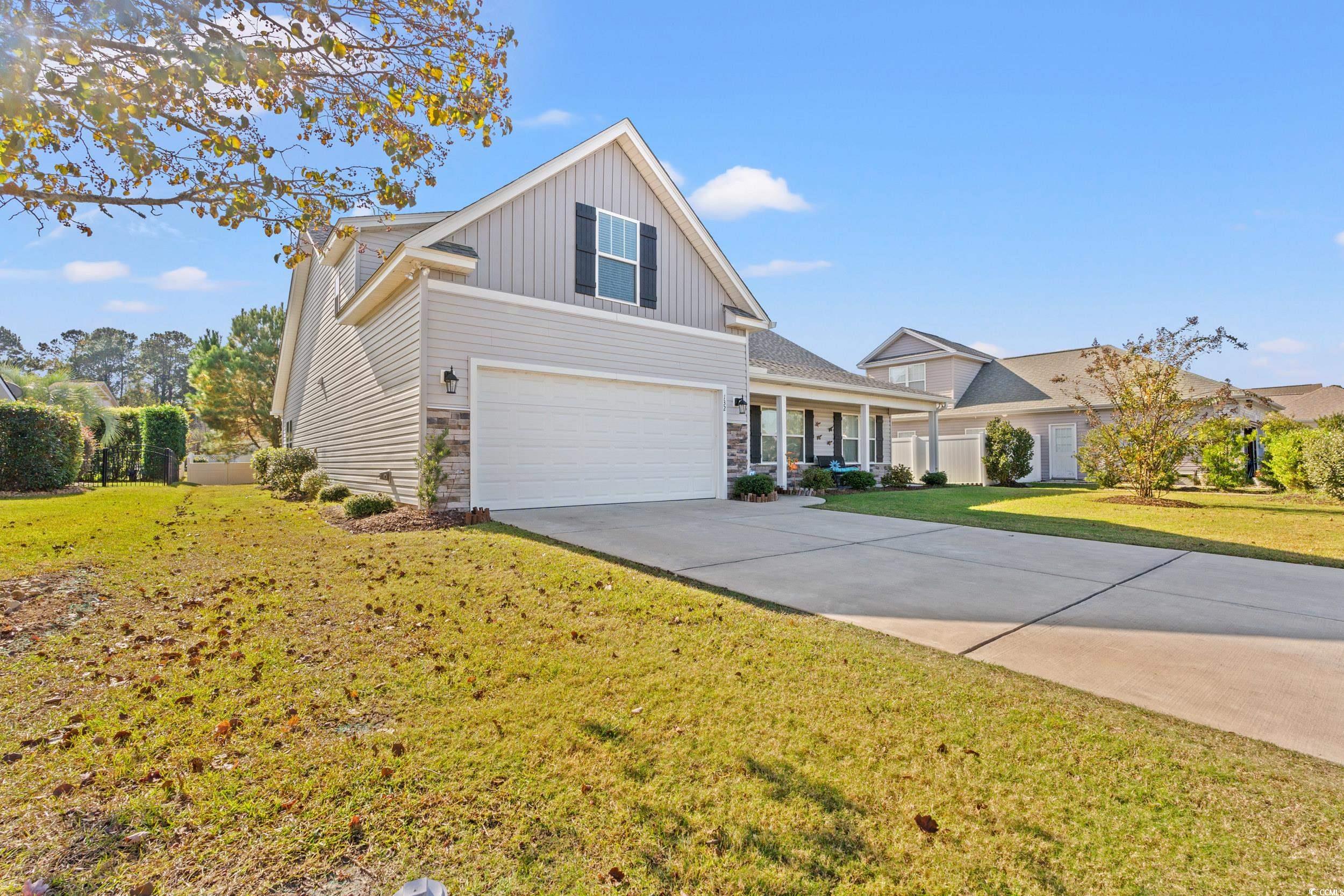 132 Fox Den Drive Murrells Inlet, SC 29576 - Photo 28 of 35 Traditional-style home featuring covered porch, a front lawn, concrete driveway, board and batten siding, and an attached garage