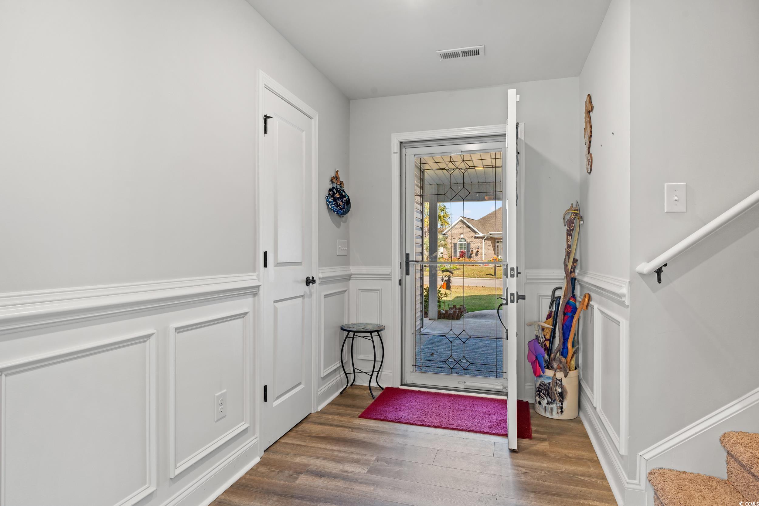 132 Fox Den Drive Murrells Inlet, SC 29576 - Photo 32 of 35 Entryway with a decorative wall, wainscoting, stairway, and wood finished floors