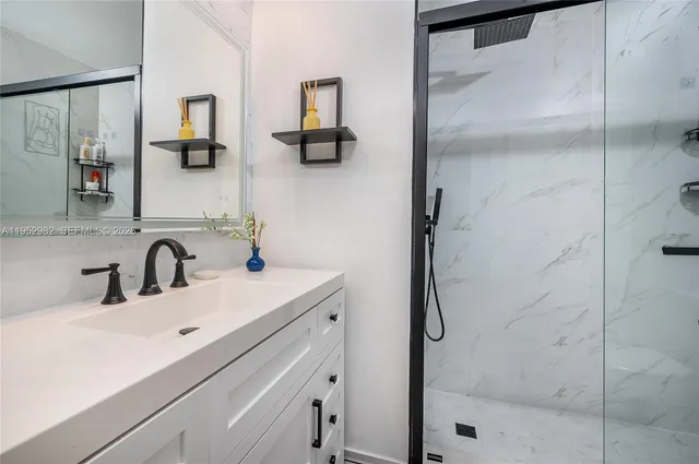 a bathroom with a sink vanity and shower