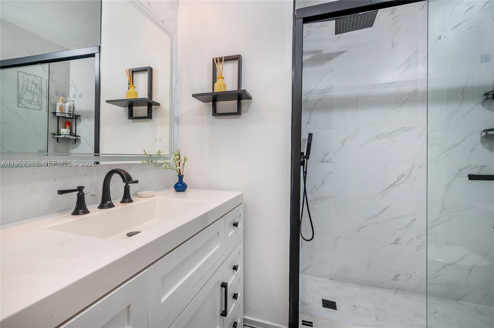 15250 Southwest 134th Place, Unit 102 Miami, FL 33177 - Photo 16 of 23 a bathroom with a sink vanity and shower