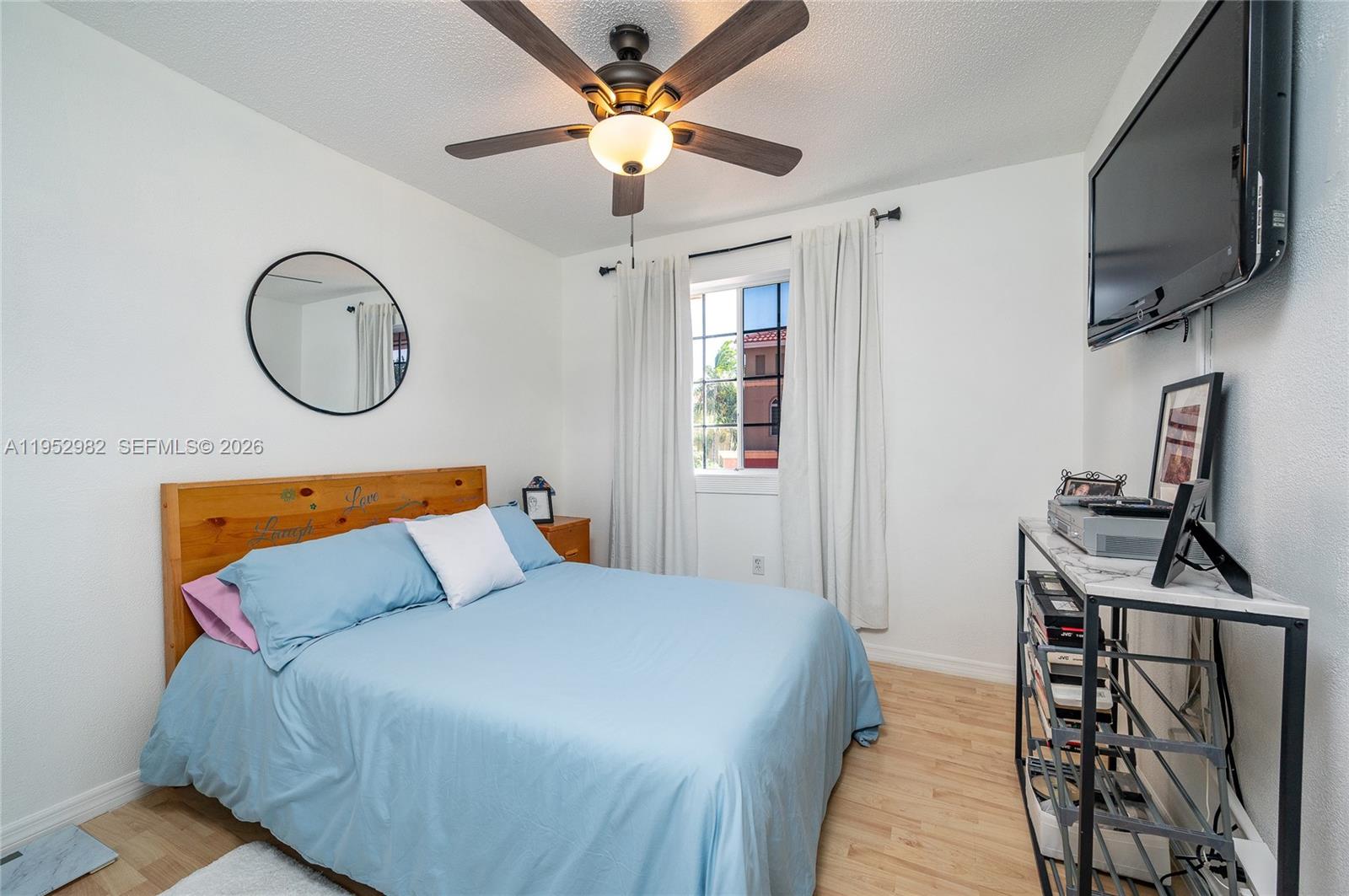 15250 Southwest 134th Place, Unit 102 Miami, FL 33177 - Photo 17 of 23 a bedroom with a bed a flat tv screen and a dresser