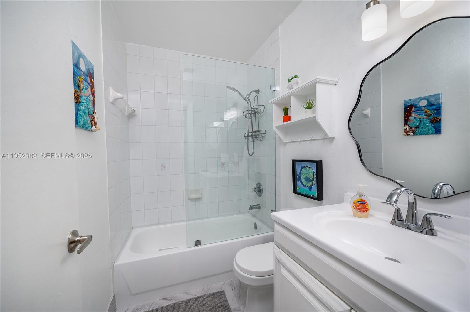 15250 Southwest 134th Place, Unit 102 Miami, FL 33177 - Photo 20 of 23 a bathroom with a sink a toilet and a mirror