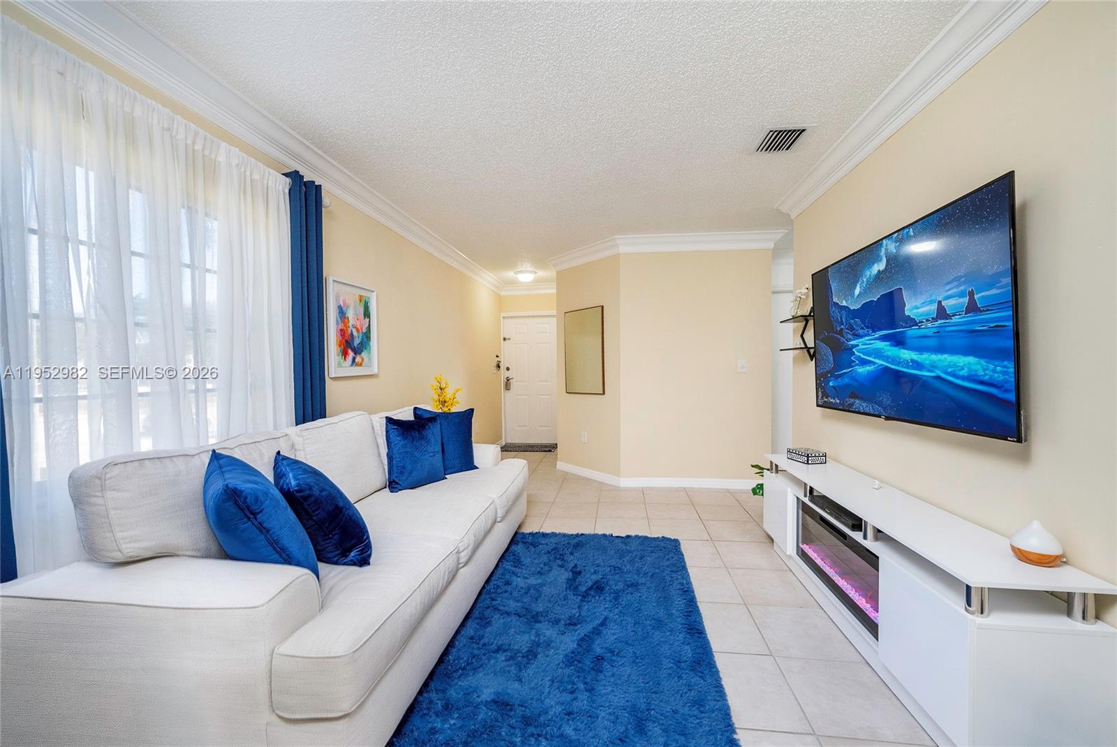 15250 Southwest 134th Place, Unit 102 Miami, FL 33177 - Photo 7 of 23 a living room with furniture and a flat screen tv