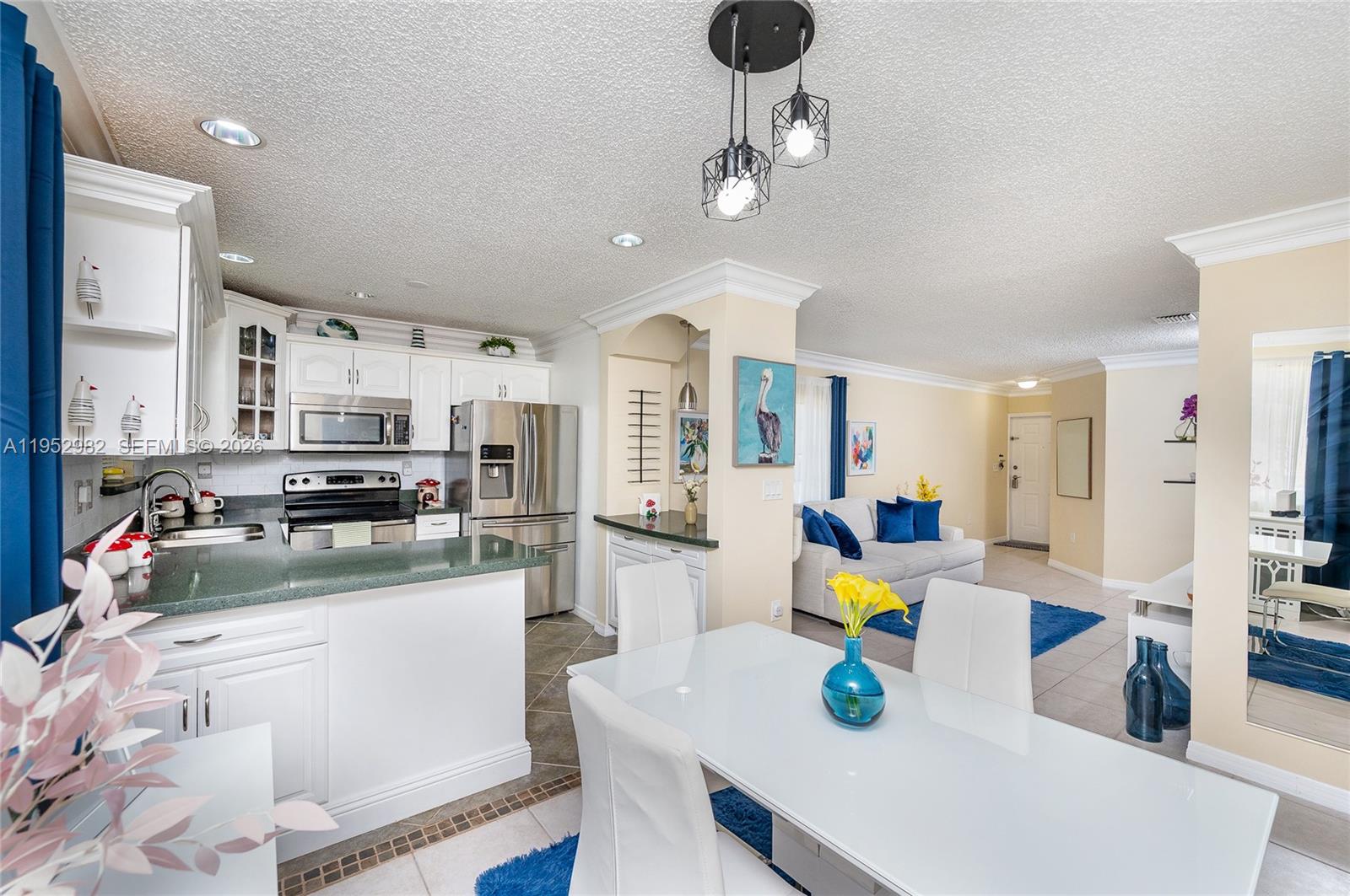 15250 Southwest 134th Place, Unit 102 Miami, FL 33177 - Photo 10 of 23 a kitchen with stainless steel appliances wooden floor dining table and chairs