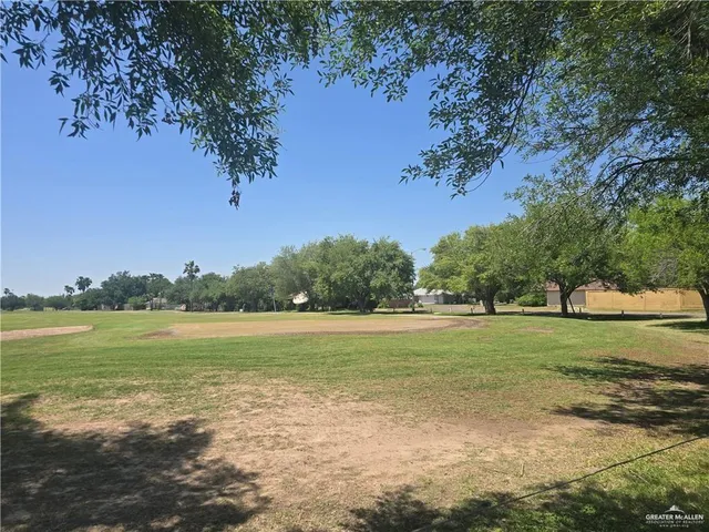 a view of a field with an trees in the background