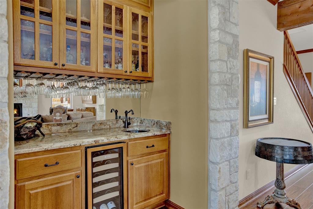 5255 Lookout Ridge Drive Marble Falls, TX 78654 - Photo 25 of 40 Wet bar has wine chiller fridge, granite counters, glass panel cabinets, wine glass rack hangers