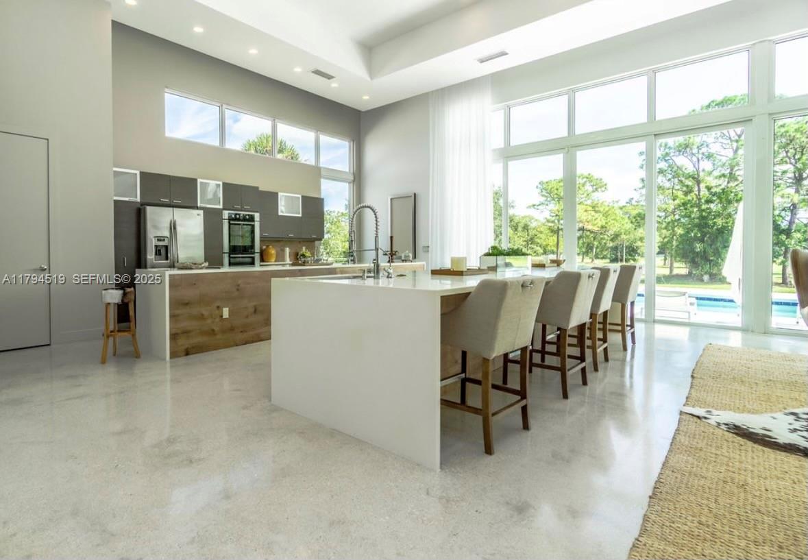 1901 Southeast Ranch Road South Jupiter, FL 33478 - Photo 15 of 53 a dining hall with stainless steel appliances a dining table and chairs