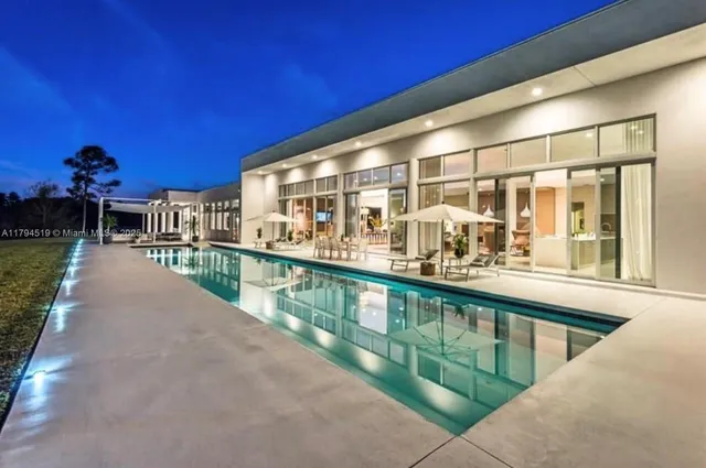 a view of a house with swimming pool and sitting area