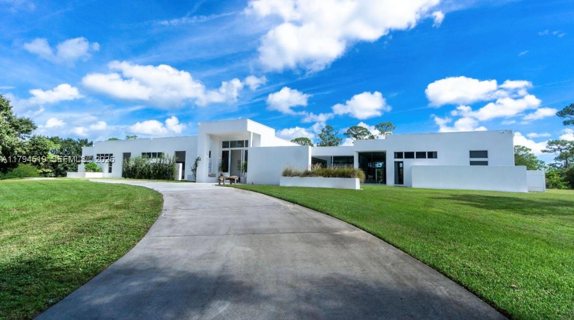 1901 Southeast Ranch Road South Jupiter, FL 33478 - Photo 7 of 53 a front view of a house with a garden and yard