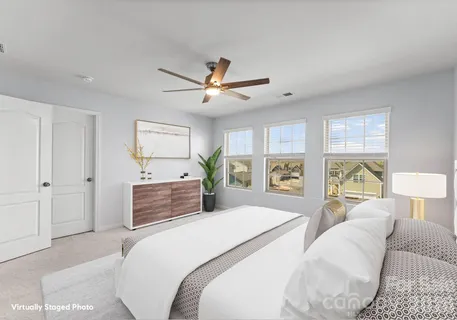 a bedroom with a large bed and a chandelier