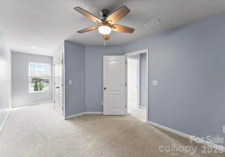 an empty room with windows and ceiling fan