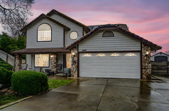 a front view of a house with a yard and garage