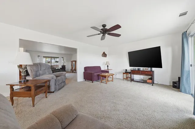 a bedroom with a bed a flat screen tv and a window