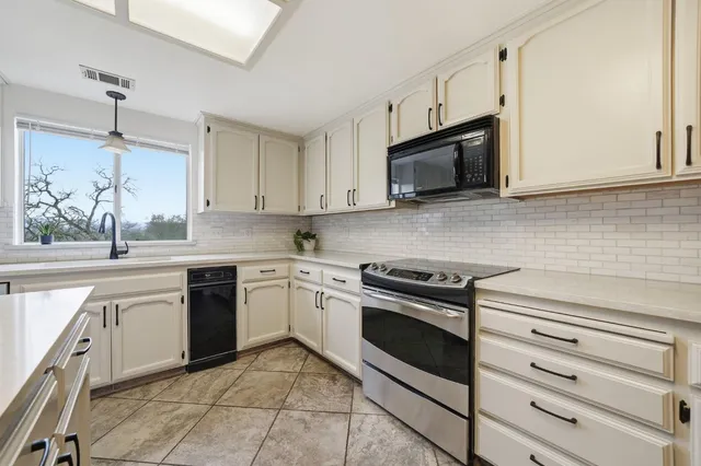 a kitchen with white cabinets and appliances