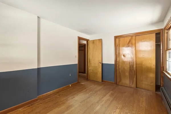 a view of an empty room with wooden floor