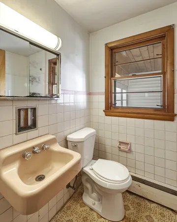 a bathroom with a sink a toilet and mirror