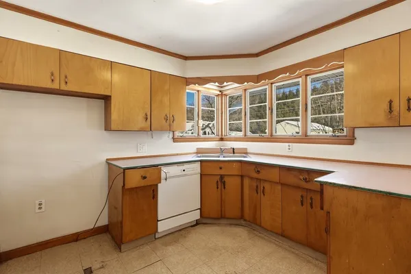 a utility room with stainless steel appliances granite countertop a sink and cabinets