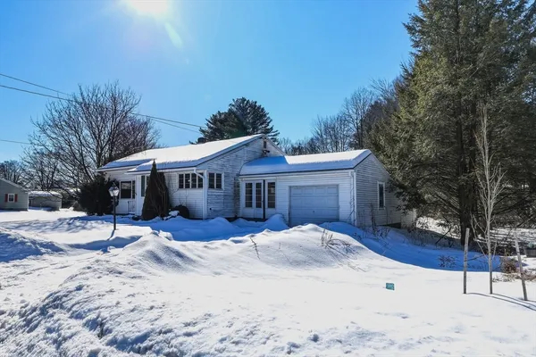 a view of a house with a yard covered in snow